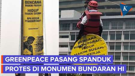 Greenpeace Bentangkan Spanduk Protes Di Monumen Bundaran HI, Turun Pakai Kabel Sling